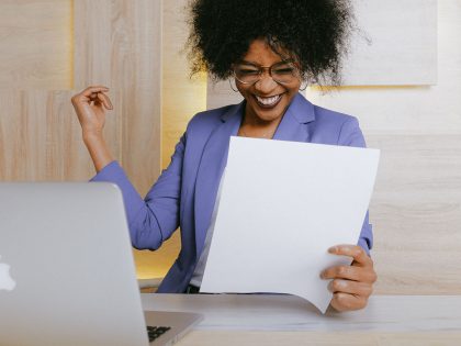 Business woman smiling holding a paper